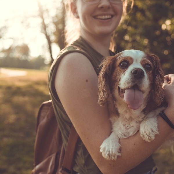 woman hiking with Cavalier King Charles Spaniel